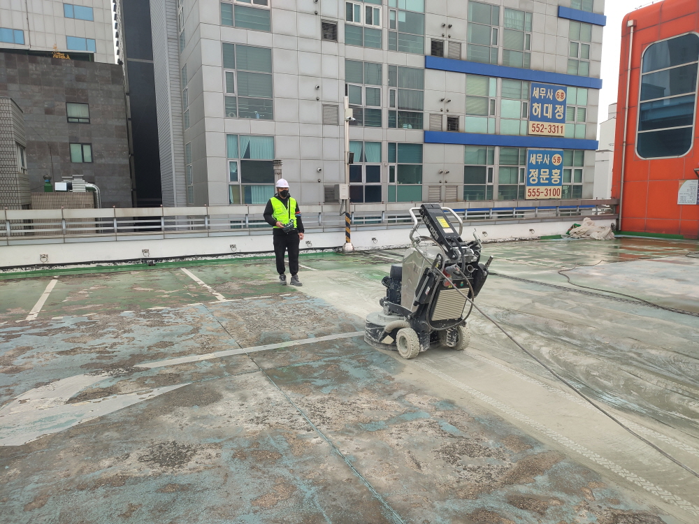 현장에서 공사 작업이 진행 중인 모습입니다. (장비와, 설명드립니다) · 자연광이 어우러져 콘크리트의 고급스러운 질감이 드러납니다.